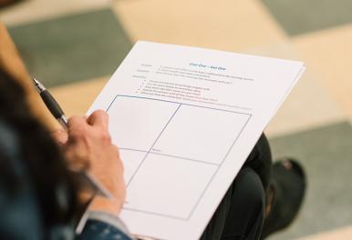 An intern fills out a form during Art Summit.