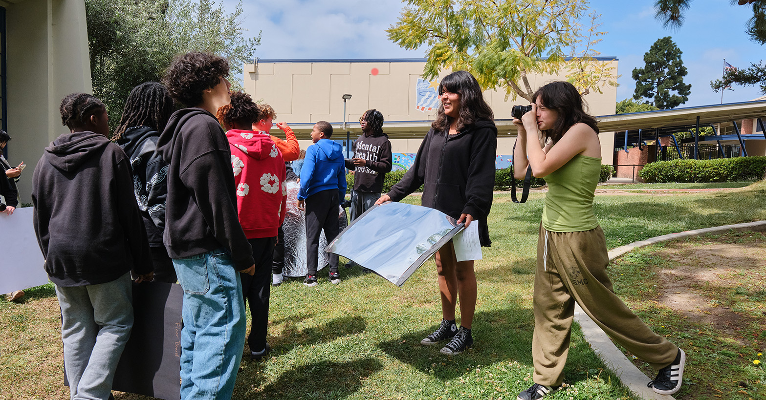 Students take photos on a campus greenspace