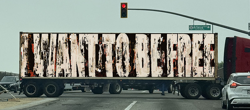 image of a semi struck with the message 'I Want To be Free' Stenciled on its side