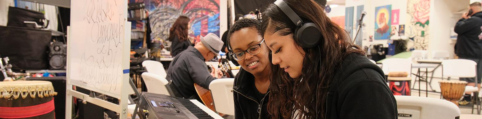 Two High School Age Girls playing a piano
