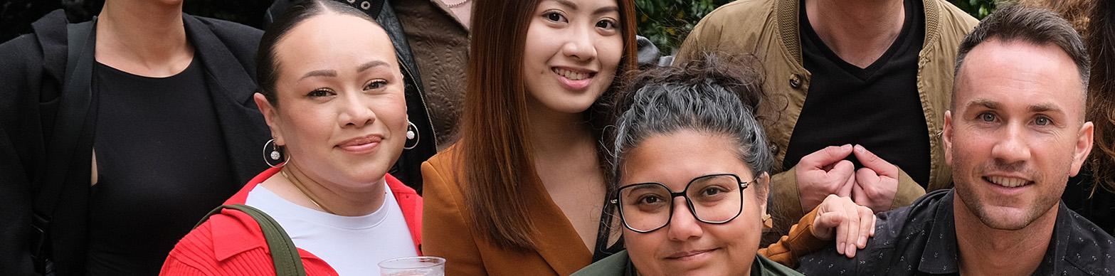 A group of multi-cultural individual pose from a group photo
