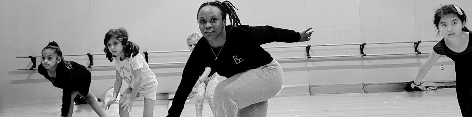 A black dancer instructs a group of young girls