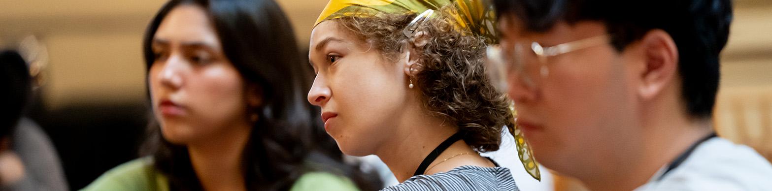 Three 20 something interns listen to someone off camera speaking