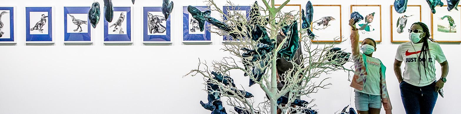 older and younger woman look at an abstract depiction of butterflies