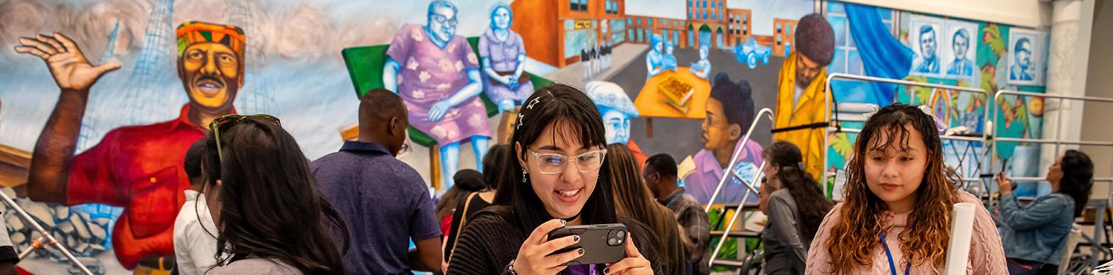 woman takes photo of art on phone