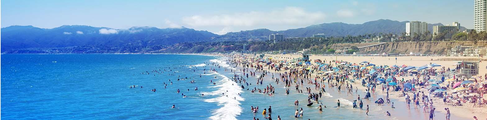 crowded beach scene with many beachgoers playing in the waves
