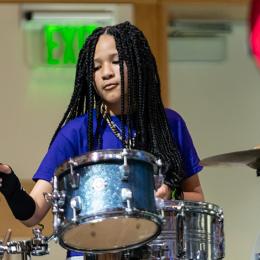 Image of a young African American Girl playing drums